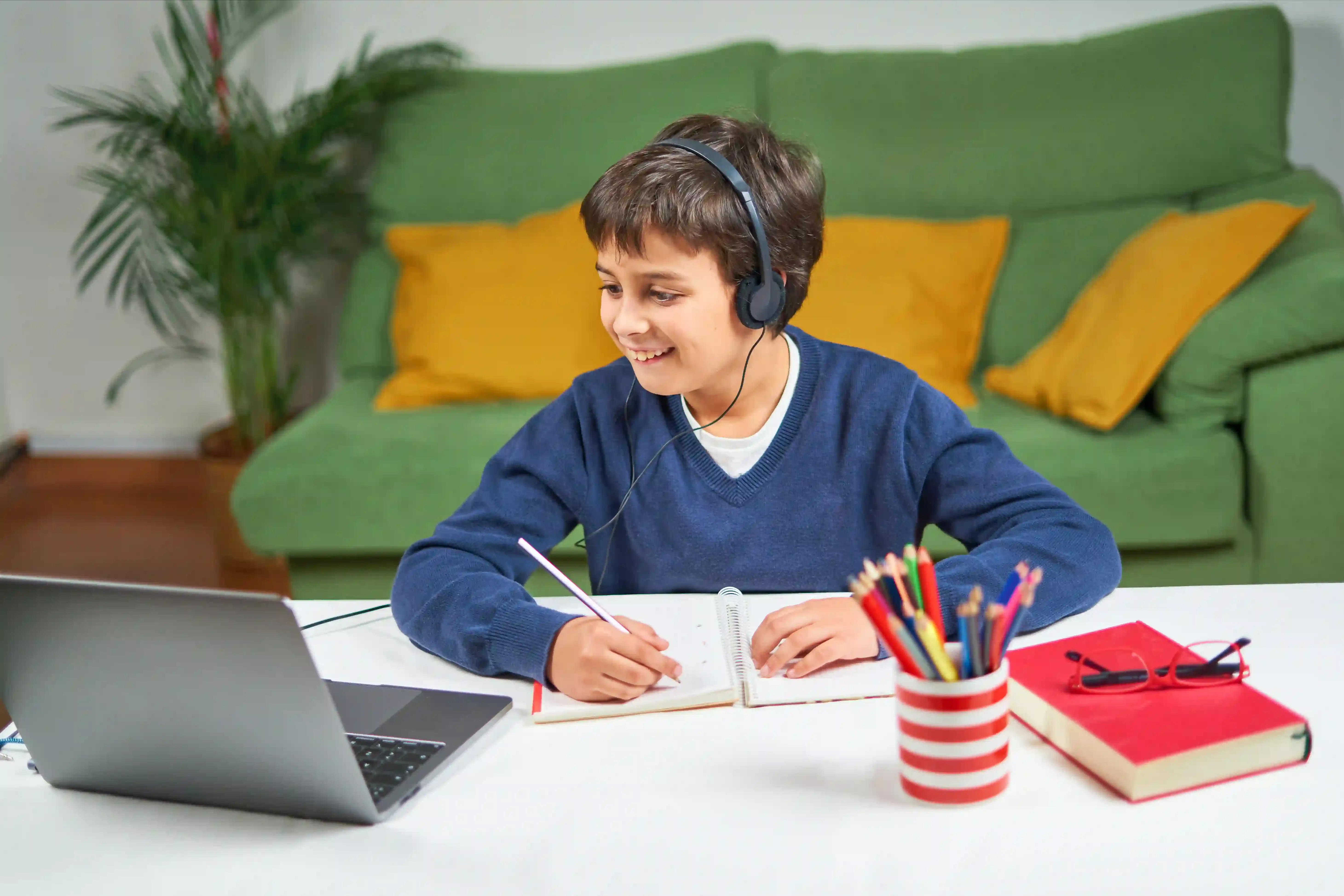 A student taking notes during an online elementary French tutoring session